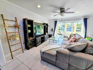 a living room with a couch and a tv at Island House #16 at Rum Point in Driftwood Village