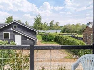 a house with a fence and a white chair at Scandinavian Lakeside Retreat-By Traum in Ansager