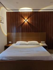 a bedroom with a large bed with a wooden headboard at Orient Glory Holidays in Edappally +22 photos