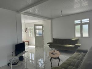a living room with a couch and a table at Maison Panorama 2 chambres in Sainte-Luce