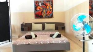 a bedroom with a bed with a fan and a painting at Studio Murdeira Side Beach, Eco Protected Bay, Pool 161B in Beirona +118 photos