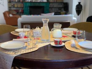 a table with plates and glasses and a bottle of milk at Volpicelli B&B in Civitella Alfedena +9 photos