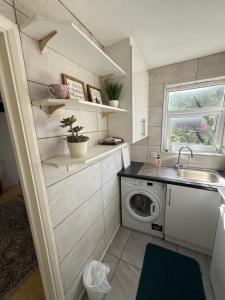 una cocina con fregadero y lavadora en Modern Wembley Apartment Walk to Stadium & Arena, en Londres