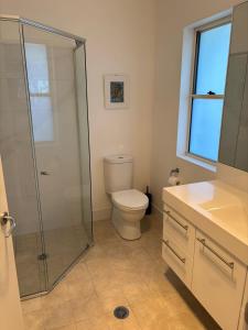 a bathroom with a toilet and a glass shower at Killarney at Old Erowal Bay in Erowal Bay +13 photos