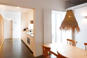 a kitchen and dining room with a table and a chandelier at Casa do Pisão - Cosy and Modern Two-Bedroom Townhouse in Angra do Heroísmo