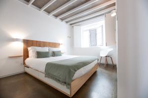 a bedroom with a large bed with a wooden headboard at Casa do Pisão - Cosy and Modern Two-Bedroom Townhouse in Angra do Heroísmo