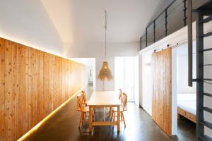a dining room with a table and chairs and a bed at Casa do Pisão - Cosy and Modern Two-Bedroom Townhouse in Angra do Heroísmo +9 photos