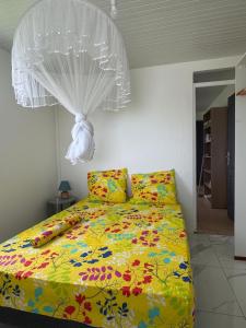 a bedroom with a bed with a comforter and a ceiling at Maison Panorama 2 chambres in Sainte-Luce