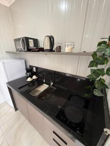 eine Küche mit einer schwarzen Arbeitsplatte und einem Herd in der Unterkunft Studio Laranjeira in Palmas