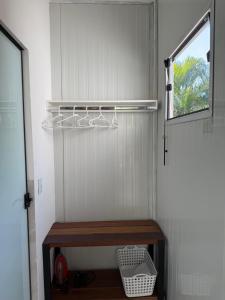 Zimmer mit einer Holzbank und einem Fenster in der Unterkunft Studio Laranjeira in Palmas