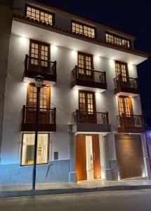 a large white building with balconies and a street light at Hoteles Silva Inn in Cajamarca