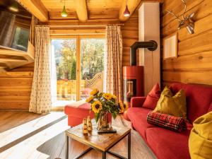 a living room with a red couch and a fireplace at Nature Lodge Kaprun B in Kaprun