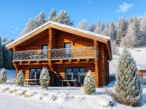 a log cabin in the snow with a balcony at Jenig 4B in Jenig