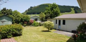 a yard with a white house and a mountain at Harmonious Social Retreat in Rotorua