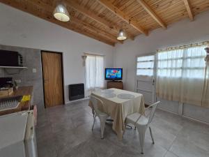 a dining room with a table and chairs and a tv at Rincón del Valle Gaiman in Gaiman