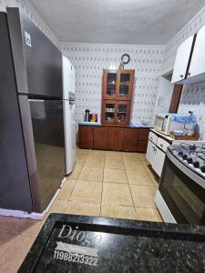 Il comprend une cuisine équipée d'un réfrigérateur. dans l'établissement Casa Praia Grande WIFI 3dorm 2ban 2carr churrasq 400mts da praia Tupi, à Praia Grande