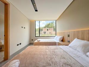 a bedroom with two beds and a large window at Apartamento de lujo a 3 minutos del Aeropuerto JMC 201 in Rionegro +13 photos