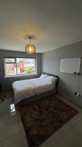 グレート・バーにあるFamily & Contractors 3 BR Bungalow Cot Garden Netflix Coffee Stationのベッドルーム1室(窓、ラグ付)