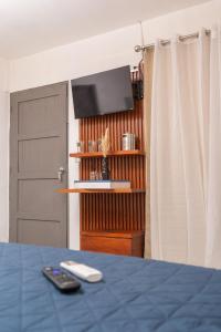 a room with a bed and a television and a door at Cadejo Brewing Company El Sunzal in Tamanique +44 photos