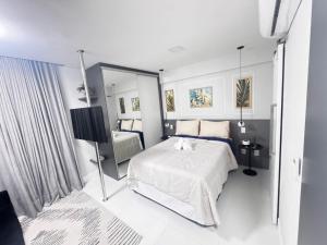 ein weißes Schlafzimmer mit einem Bett und einem Spiegel in der Unterkunft 809 Studio Ideal for Vacation and Business Sea View in Salvador