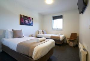 a hotel room with two beds and a window at The Island Accommodation in Phillip Island