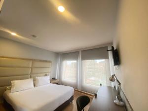 ボゴタにあるHotel Hill House Usaquénの白いベッドと窓のある寝室