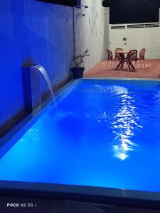 a blue swimming pool with a water fountain at Casa Mineira - Flats novos em Ponta de Mangue - Maragogi in Maragogi