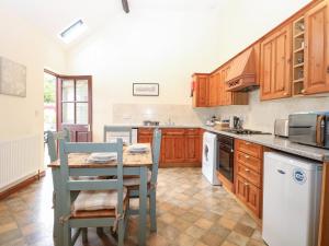 a kitchen with wooden cabinets and a table and chairs at Willow in Wood Norton