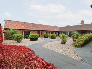 a courtyard of a building with red flowers at Willow in Wood Norton