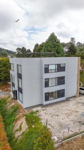 a white building sitting on top of a field at Apartamento de lujo a 3 minutos del Aeropuerto JMC 101 in Rionegro