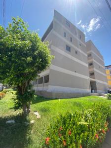 a building with a tree in front of it at Charme Barra Mar in São Luís