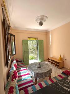a living room with a table and a window at Dar Amallay in Tamraght Oufella