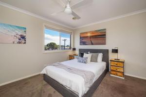 Una habitación blanca con una cama y una ventana en Capel Grand Villa - Pet-Friendly Beach Escape, en Rosebud