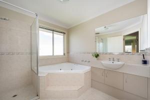 Un baño con bañera, lavabo y espejo. en Capel Grand Villa - Pet-Friendly Beach Escape, en Rosebud 22 fotos más