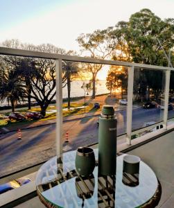 a table with two coffee cups on a balcony with a view of a street at Ap 208 Experimenta los mágicos Atardeceres y las vistas in Colonia del Sacramento