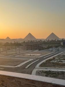 a view of the pyramids at sunset from a building at New Galleria Pyramids Hotel in Cairo +50 photos