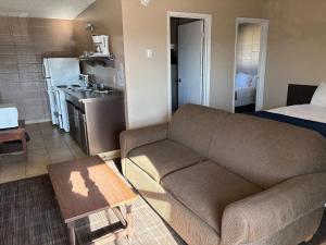 a living room with a couch and a kitchen at Alaskan Motel in Fox Creek