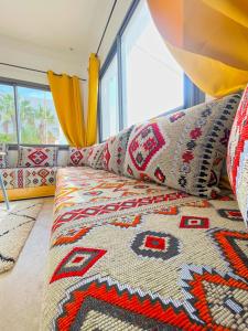 a living room with a couch with a rug at Mira bay surf house in Imsouane