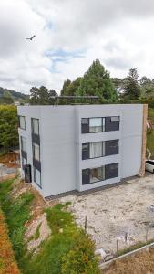 a white building on top of a field at Apartamento de lujo a 3 minutos del Aeropuerto JMC 102 in Rionegro