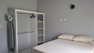 Un dormitorio blanco con una cama y un armario. en Rest Easy at Cunningham Suites, en Ottleyʼs Village