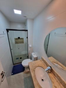a bathroom with a sink and a toilet and a mirror at Apartamento Frente pra Praia em Resort in Arraial do Cabo +8 photos