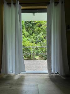 une fenêtre ouverte avec vue sur un balcon dans l'établissement Cinnamon Cottage - Peaceful retreat in nature, à Soufrière 32 autres photos