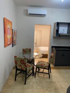 a living room with a glass table and two chairs at Mereri downtown appartments in Oranjestad