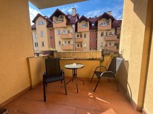 un balcone con tavolo e sedie e un edificio di Apartament #SIKORSKIEGO FV PARKING BALKON a Rzeszów