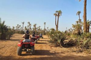 des gens conduisant des VTT sur un chemin de terre bordé de palmiers dans l'établissement Dar Mawati, à Marrakech