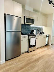 eine Küche mit einem Kühlschrank und Geräten aus Edelstahl in der Unterkunft Heart of Hollywood Walk of Fame - Free Parking, Pool, Gym, Rooftop Views, centrally located, WIFI in Los Angeles + 8 Fotos