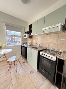 a kitchen with a stove and a table in it at Apart Gob Campos con vista in Ushuaia +7 photos