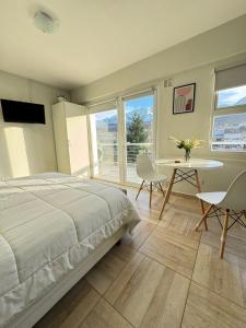 a bedroom with a bed and a table and chairs at Apart Gob Campos con vista in Ushuaia