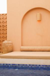 a bench next to a wall next to a swimming pool at Pasir 1 - A stylish 2 bed duplex in Bingin w pool in Bingin Beach