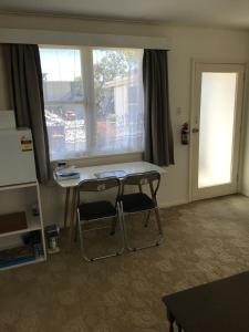 a desk and two chairs in a room with a window at The Bivvy at Hutt Central in Lower Hutt +10 photos